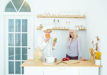 Senior mother and the adult daughter on home kitchen