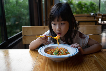 Asian child girl eating Spaghetti