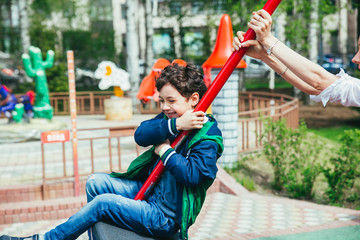 Wall Mural - Little pretty boy is having fun outdoor. Playing in children zone in amusement park.