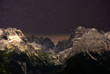 Wall Mural - night sky over the mountains. the dolomites in modonna di campiglio, italy.