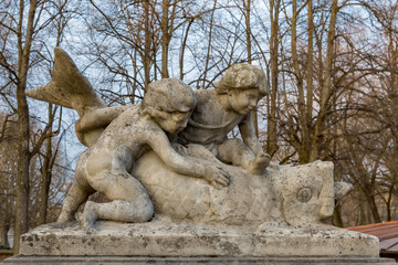 Zwei Kinder berühren einem Fisch aus Stein