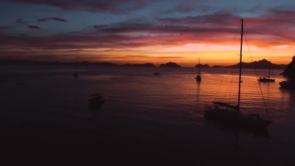 Wall Mural - Aerial view of boats and yachts in the tropical bay on the sunset. El Nido, Palawan, Philippines. Marine tropical sunset over the sea. Travel concept.