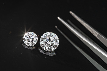 Compared 1.00 and 2.50 carat size diamonds on black background