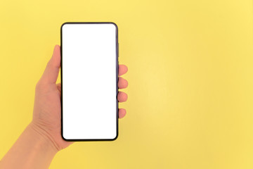 Human hand holding smartphone with white screen background.