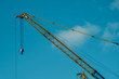 Yellow crane at construction site with blue sky