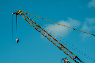 Yellow crane at construction site with blue sky