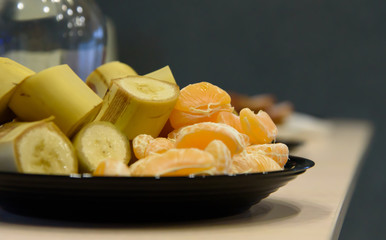 Mandarin orange fruits, peeled and ready to eat, with sliced ​​bananas. healthy food with vitamins and minerals