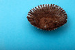 Empty chocolate muffin wrapper on a blue background