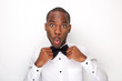 © mimagephotos - african american man making a face white adjusting bowtie