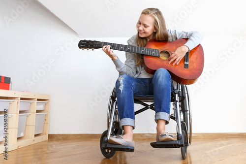 Cuadros en Lienzo Invalid girl on wheelchair plays the guitar in day room.