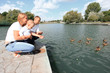 © yurolaitsalbert - happy parents with their little son sitting on the lake pier