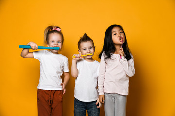 Wall Mural - dental hygiene. happy little cute children with toothbrushes.