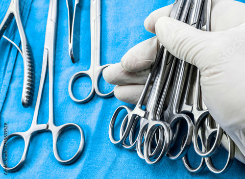Cuadros en Lienzo Surgeon working in operating room, hands with gloves holding sci