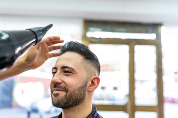 Wall Mural - Young Man Getting a Hairstyle in a Barbershop.