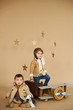 © jul14ka - two brothers are played with a toy airplane and a suitcase on a beige background. dreams and travel concept