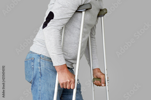 Fotomural Man on crutches on a gray background