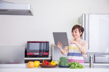 Poster - キッチンでタブレットPCを見る女性