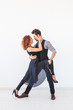 © satura_ - Social dance, bachata, kizomba, zouk, tango concept - Man hugs woman while dancing over white background in studio