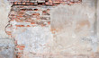 © vejaa - Old grungy red brick wall with peeled beige stucco background. Vintage retro plaster wall with dirty cracked scratched texture background