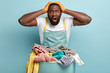 © wayhome.studio  - Frustrated dark skinned bearded man keeps both hands on head, face problem of brocken washing machine, has to do hand wash, busy with household duties, laundry, stands near basin of dirty clothes