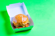 ready burger in carton box on green background