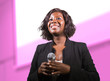 © TheVisualsYouNeed - confident black afro American business woman with microphone speaking in auditorium at corporate event or seminar giving motivation and success coaching