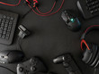 © ekkaphan - gamer workspace concept, top view a gaming gear, mouse, keyboard, joystick, headset, mobile joystick, in ear headphone and mouse pad on black table background with copy space.