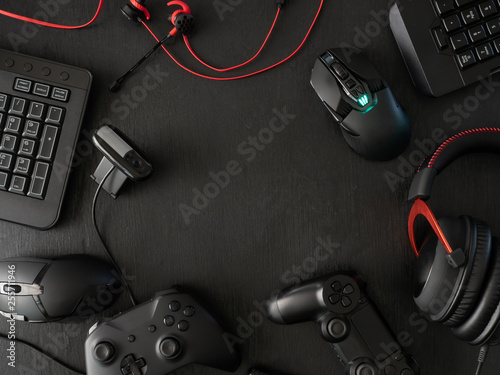gamer workspace concept, top view a gaming gear, mouse, keyboard, joystick, headset, mobile joystick, in ear headphone and mouse pad on black table background with copy space Wallpaper Mural