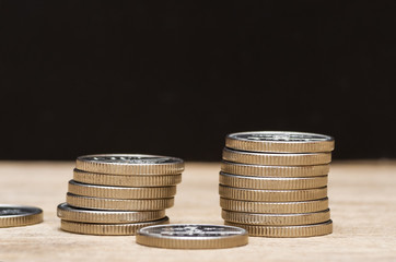 Many euro coins stacked on black background.