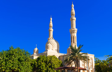 View of the facade of the building of the mosque Jumeirah, Dubai, United Arab Emirates. Isolated on blue background.