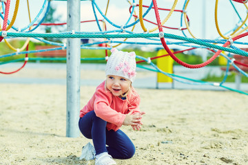 Active cute little girl on playground. child playing outdoors in summer