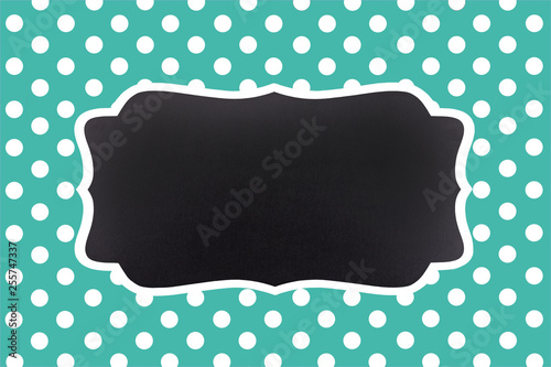 Turquoise background with symmetrical white polka dots and an empty chalkboar...
