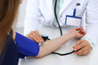 © rogerphoto - Unknown doctor woman checking blood pressure of female patient, close-up. Cardiology in medicine  and health care concept
