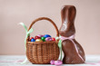 Chocolate easter bunny and sweets on pink background, easter concept background.