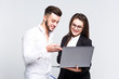 © Тарас Нагирняк - Two young happy smiling successful businesspeople working with laptop on white background. Business concept.
