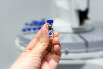 Wall Mural - scientist holds a chemical sample vial. people hand holding a test tube vial sets for analysis.labor