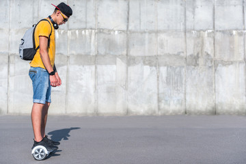 Wall Mural - Full length of man looking at his feet while standing on gyro scooter