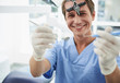 © Yakobchuk Olena - Cheerful male dentist demonstrating instruments on blurred background