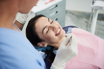 Wall Mural - Beautiful young woman waiting for treatment at dental clinic