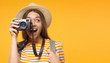 Leinwandbild Motiv Tourism concept. Horizontal banner of excited young woman tourist holding photo camera, isolated on yellow background with copy space