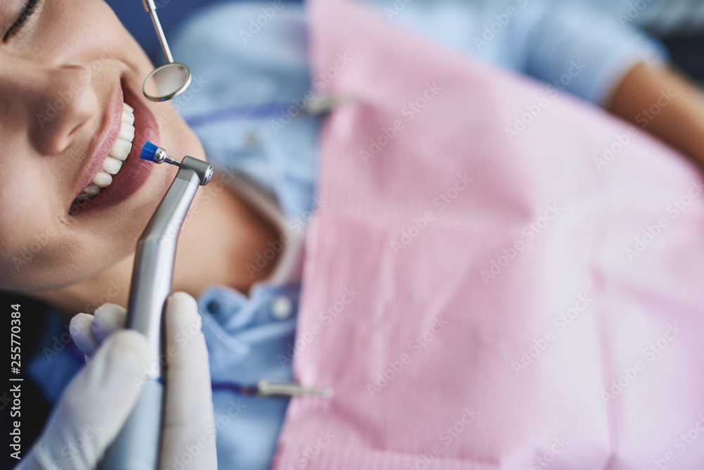 Young lady lying in dentist chair during dental procedure
