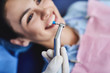 © Yakobchuk Olena - Male dentist holding instrument for teeth cleaning while young lady smiling