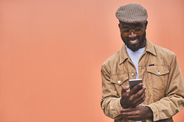 Wall Mural - Waist up of a smiling afro American man with phone