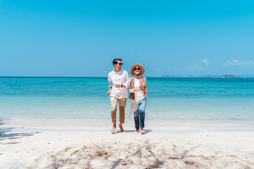 Wall Mural - Young happy muslim couple white dress on running seashore. Travel Vacation Retirement Lifestyle Concept. young couple running together on the beach in vacation day. summer time.