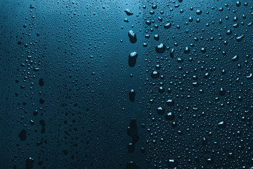 Blue surface with shiny water drops, background