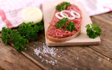 Wall Mural - slice of bread with minced meat, parsley and onions - on rustic wooden table - breakfast bread - pork mett