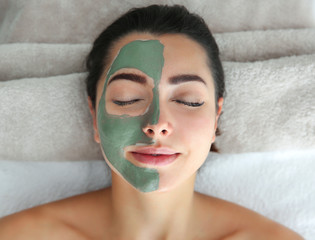 Poster - Pretty woman with clay mask on her face in spa salon, above view