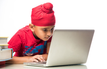 Sikh Indian kid/boy studying using laptop or playing games