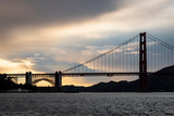 Fototapeta Most - Clouds behind the Golden Gate Bridge at sunset.
