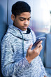 © Oleksandr - A black man uses a mobile phone. Teen sitting on the stairs playing a game on the smartphone. Afro american boy is writing a message.